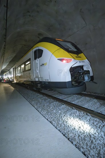 A yellow and white train passes through a tunnel at night, fire department exercise on the Hermann Hesse Railway, Ostelsheim, Germany