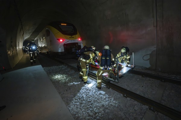 Firefighters rescue a person on the tracks in a tunnel at night, fire brigade exercise on the Hermann Hesse railway, Ostelsheim, Germany