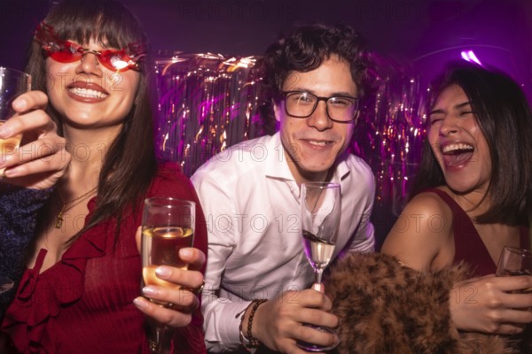 Young friends enjoying a vibrant night out with drinks, smiling and laughing under club lights, sharing moments of happiness and celebration at a lively social event