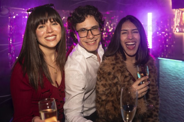 Three diverse young friends celebrating and having fun together at a vibrant nightclub, holding champagne glasses and laughing under purple neon lights