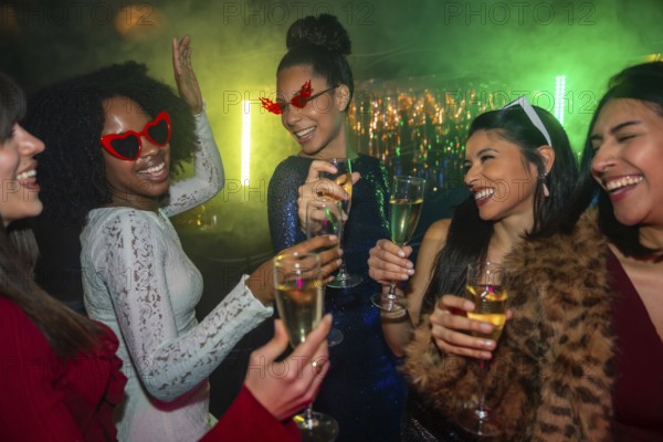 Diverse group of smiling young women toasting with champagne in a vibrant nightclub, celebrating a special occasion with colorful lights, dancing, and joyful togetherness