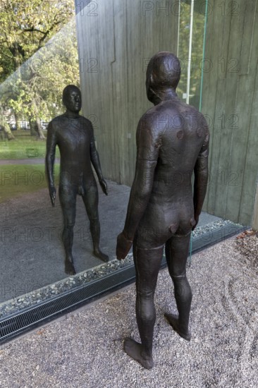 Male figure looking at her real reflection, Reflections II sculpture by sculptor Antony Gormley, Lehmbruck Museum, Duisburg, North Rhine-Westphalia, Germany