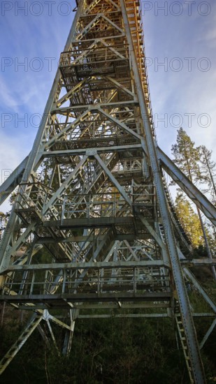 Vertical view of a high metal bridge, old railroad bridge, in front of a bright blue sky, Ziemestalbrücke, Thuringian Forest