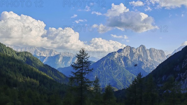 Wide mountain landscape under cloudy sky with forest cover, Slovenia