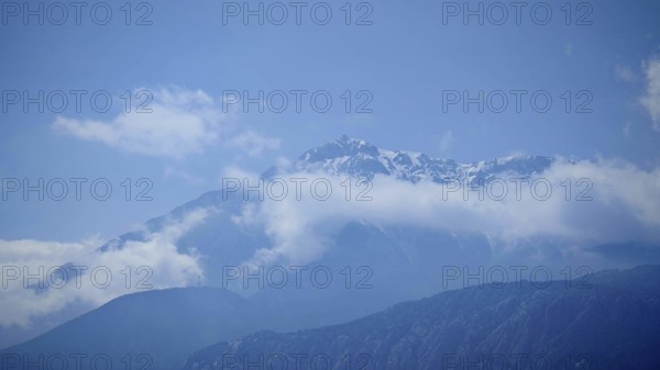 Snowy mountain peaks of Tahtali Dagi jut out of surrounding clouds, Lycia, Turkey