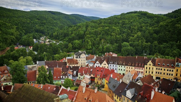 Panorama of a city with colorful roofs surrounded by wooded hills, view of Loket from above, Czech Republic