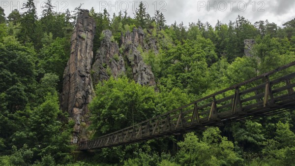 Suspension bridge leads across a river through wooded rocks, Hans Heiling Rocks, Eger Valley, Czech Republic
