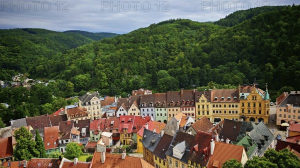 Historic town with colorful roofs surrounded by wooded hills, view of Loket, Czech Republic