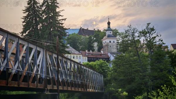Idyllic city view with old railroad bridge and tower over a river in the evening light, Loket, Czech Republic