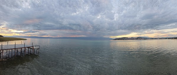 Panoramic view of a lake at sunset, with a jetty in the foreground, Lake Ohrid, North Macedonia