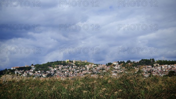 A city on a hill with a wide view of clouds and vegetation below, Ohrid, North Macedonia