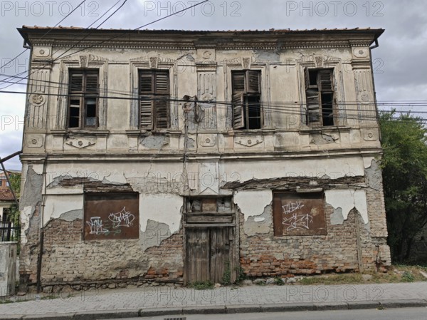 An old, dilapidated building with closed shutters and crumbling façade, Ohrid, North Macedonia