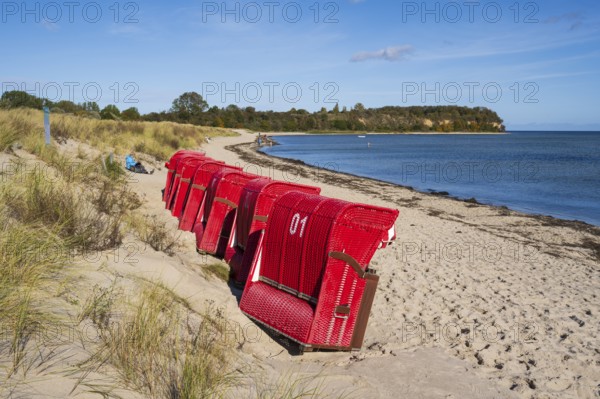 Red beach chairs side by side on sandy beach, beach and cliffs, people on the beach, autumn, Lobbe, Mönchgut, Rügen, island, Baltic Sea, Mecklenburg-Western Pomerania, Germany