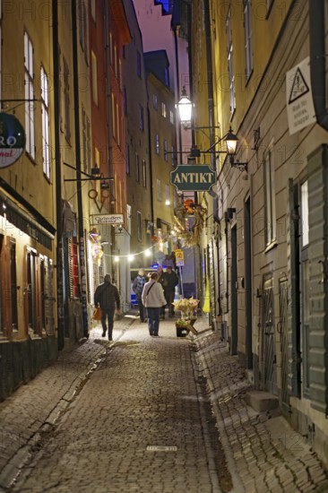 A picturesque alley at dusk with cobblestones and warmly lit historic buildings, Gamla Stan, Stockholm, Sweden