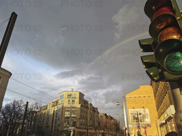 Rainbow over urban scene with traffic light and cloudy sky, Berlin