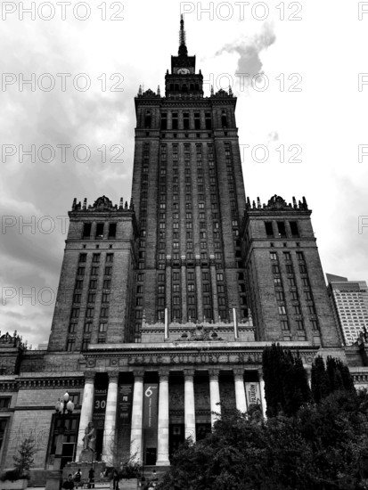 Majestic skyscraper Palace of Culture in historical style in black and white under cloudy sky, Warsaw, Poland