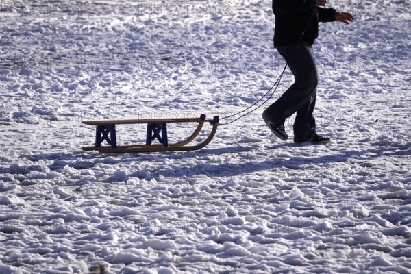 Sled in snow pulled by a man, winter, Germany