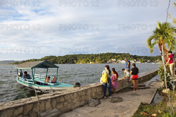 Guatemalans and a boat on the shore, Lake Petén Itzá in Flores, Petén Department, Guatemala