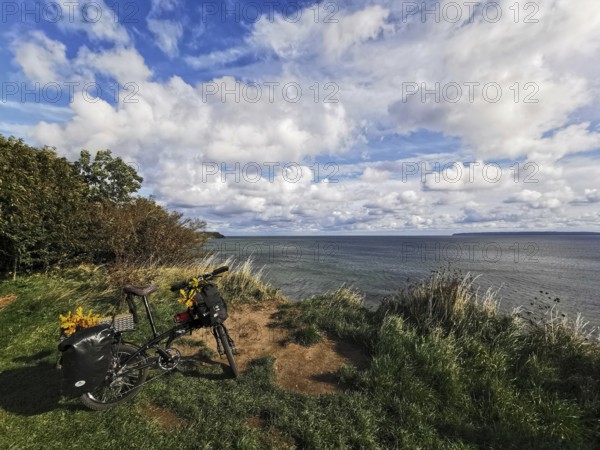 A bicycle is parked on the edge of a cliff with a sea view, Baltic Sea, Germany