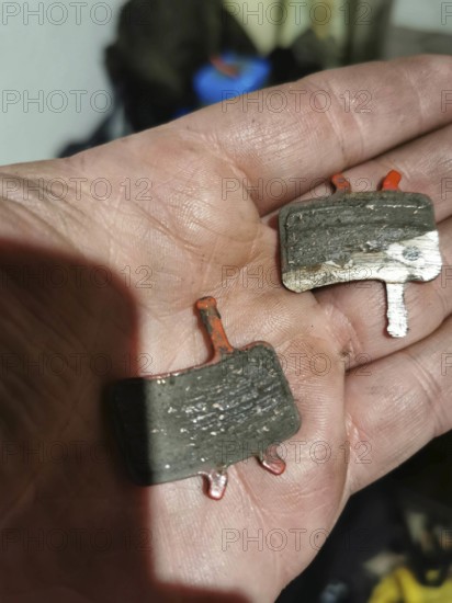 Close-up of used brake pads on one hand, bicycle, disc brakes, worn