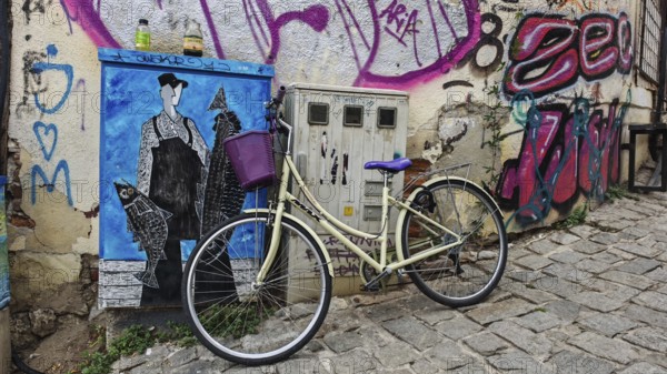 Vintage bicycle leaning against graffiti-decorated wall in urban setting, creative and lively scene, North Macedonia