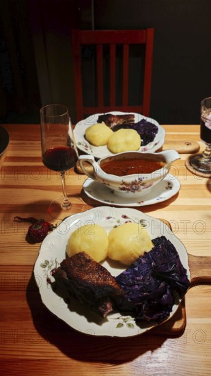 Franconian cuisine, a cozy dinner with goose breast, dumplings, red cabbage on a wooden table, Upper Franconia