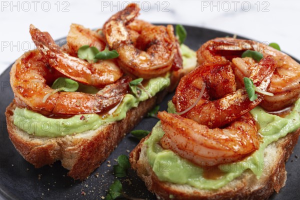 Sandwiches with avocado and caramelized shrimp, micro-greens, breakfast, on a plate, top view, homemade, no people