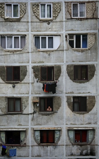 A prefabricated building with symmetrical windows and visible decay that conveys a melancholy urban atmosphere, Tbilisi Georgia