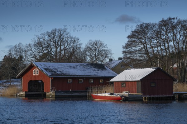 Falun-painted boathouses and motor boat, Korpoström, Korpo or Korppo, southwestern archipelago, Finland