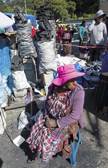 Mayan woman in traditional clothing selling charcoal at the market in Sololá, Highlands, Sololá Department, Guatemala