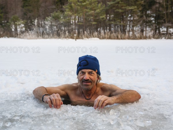 Man with cap, 55, ice bathing in an ice hole, Thumsee, Bad Reichenhall, Berchtesgadener Land, Upper Bavaria, Bavaria, Germany