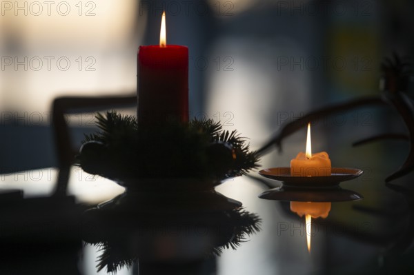 Two candles stand on a table in front of a window at dusk and create a Christmas atmosphere, Finland