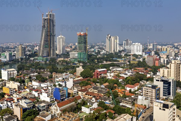 Diverse skyline of a big city with high-rise buildings and construction cranes under clear skies