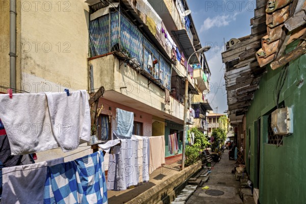 Narrow alley with colorful residential buildings and hanging laundry, lively and traditional