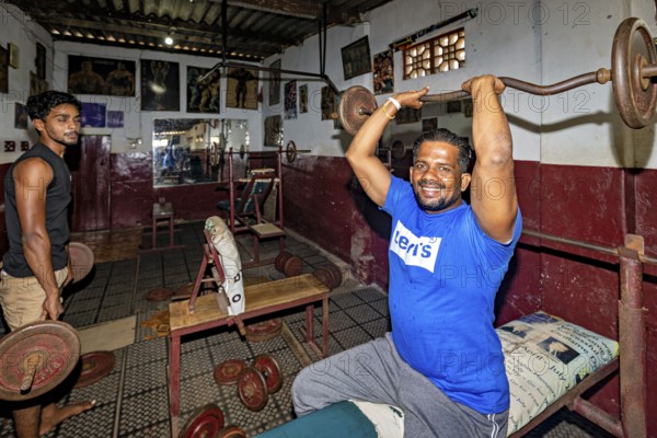 Men weightlifting in a traditional gym with rustic charm