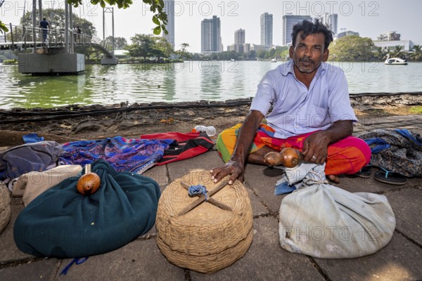Man on the riverbank with filled baskets against an urban backdrop, relaxed and traditional