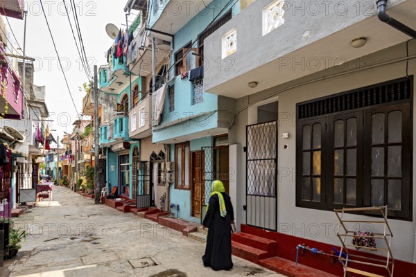 Urban street with colorful buildings and a woman in traditional clothes
