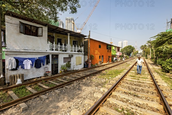 Colourful houses with laundry lines along railroad tracks in an urban setting