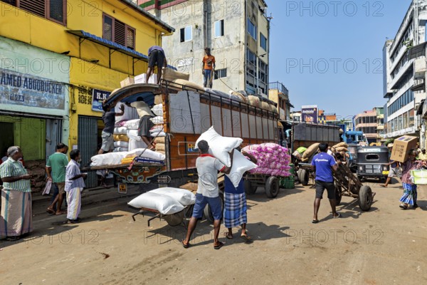 Bustling street scene in India, workers loading a truck in a market district, loading a truck in the streets of Colombo in Sri Lanka