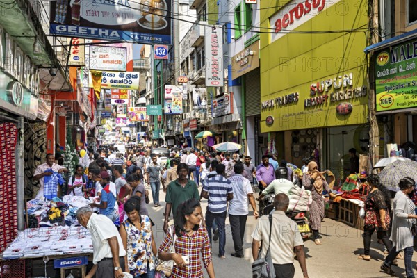 Bustling shopping street full of people, market stalls and glowing signs, the hustle and bustle of Colombo city center in Sri Lanka