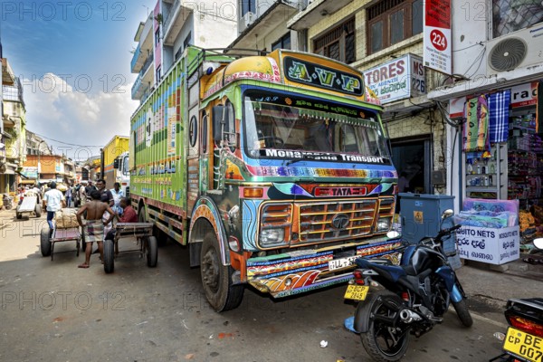Colourful truck on a busy Indian street with shops and people in sunny weather, The colorful trucks in the streets of Colombo in Sri Lanka