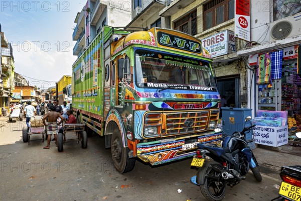 Workers load a truck with large packages on a busy city street, The colorful trucks in the streets of Colombo in Sri Lanka