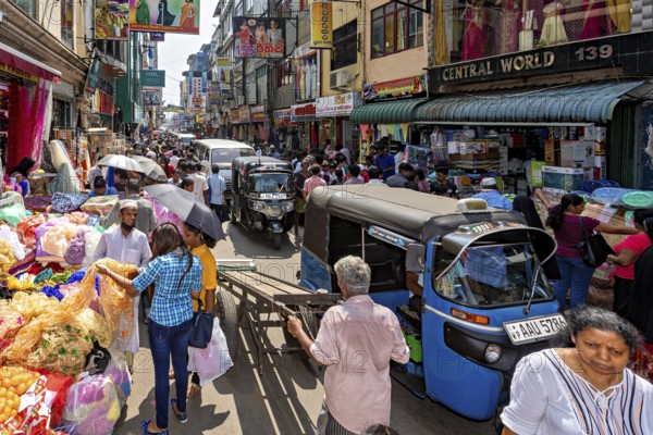 Busy street with market stalls, people and rickshaws in a busy shopping district, the hustle and bustle of Colombo city center in Sri Lanka
