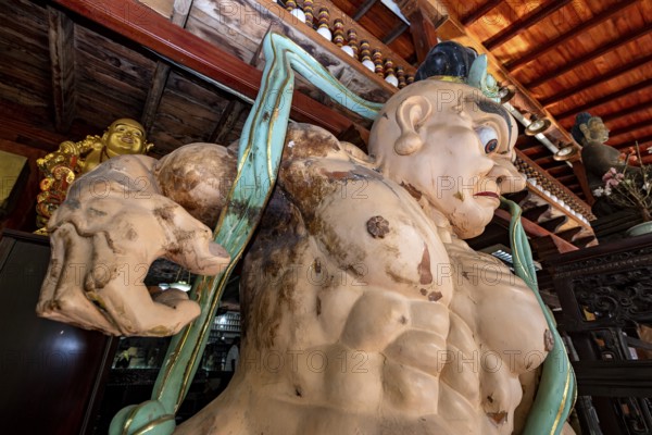 Large wooden sculpture with Buddhist theme in traditional setting, statues of gods in Colombo temples in Sri Lanka
