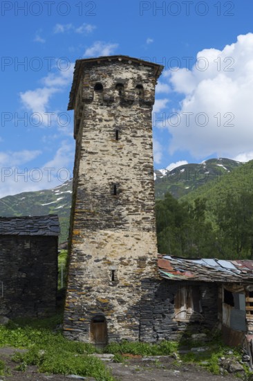 Old defensive defence tower against a backdrop of mountains and blue skies. Historical construction in the foreground, defensive tower, Ushguli, Shibiani district, Zhibiani, Upper Svaneti, Svaneti, Georgia