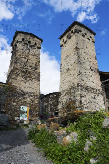 Two old stone towers under a blue sky with clouds, defensive towers, Ushguli, Ushguli, Shibiani district, Zhibiani, Upper Svaneti, Svaneti, Georgia
