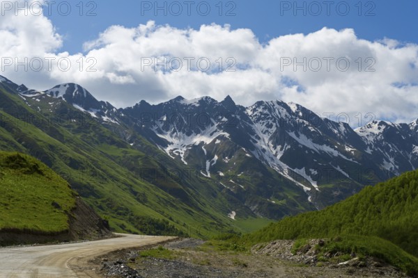 Snow-capped mountains and a road under a cloudy sky, mountains near Ushguli, Upper Svaneti, Svaneti, Georgia