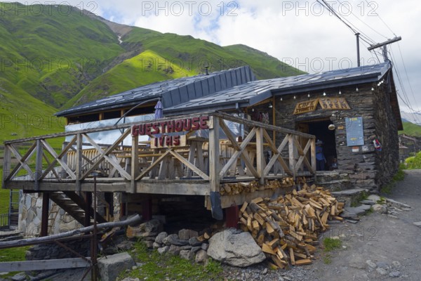 Guesthouse with wooden veranda in a mountain landscape under a cloudy sky, Cafe Svaneti, Ushguli, Ushguli, Shibiani district, Zhibiani, Upper Svaneti, Svaneti, Georgia