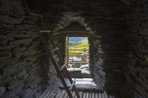 Stone interior of a defence tower with ladder and view of a green valley, in the tower of Queen Tamar, Tamara, defensive tower, Ushguli, district of Chazashi, Chazhashi, Mingrelia and Upper Svaneti region, Svaneti, Georgia