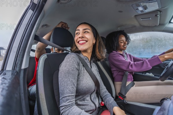 Diverse friends in athletic wear smiling in a car, seatbelts on and ready for a fun pickleball outing or active weekend road trip, excited and bonded together